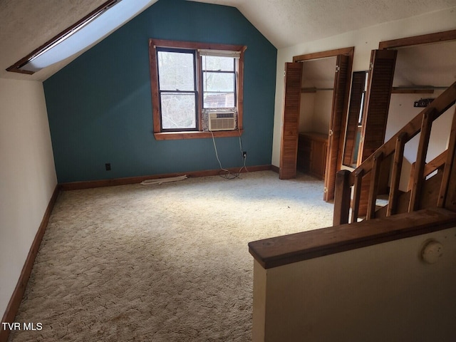 bonus room featuring cooling unit, lofted ceiling with skylight, a textured ceiling, and carpet flooring