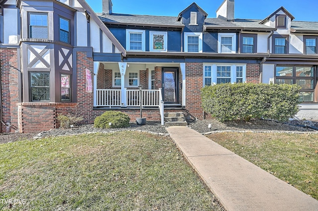 townhome / multi-family property with a porch and a front lawn