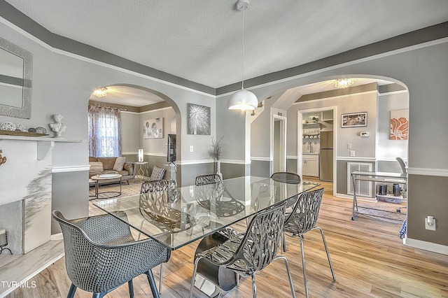 dining area with wood-type flooring and a textured ceiling