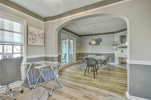 dining space with hardwood / wood-style flooring, plenty of natural light, a textured ceiling, and a notable chandelier