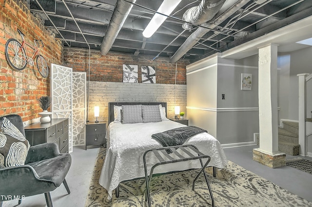 bedroom with concrete flooring and brick wall