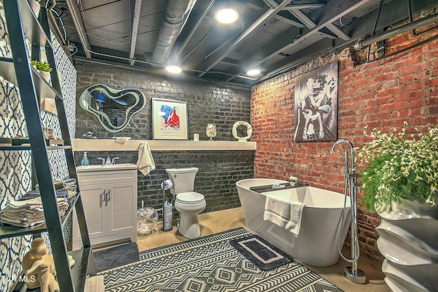 bathroom with brick wall, toilet, vanity, and a tub