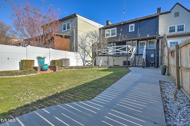 rear view of house featuring a lawn and central air condition unit