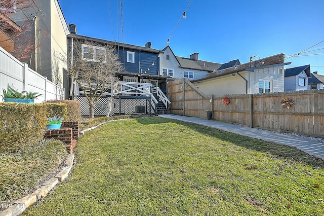 back of house with a wooden deck and a lawn