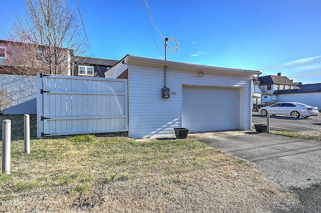 view of side of home with a garage, an outdoor structure, and a yard