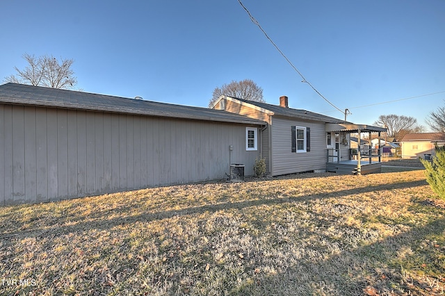 rear view of property featuring a yard and a deck