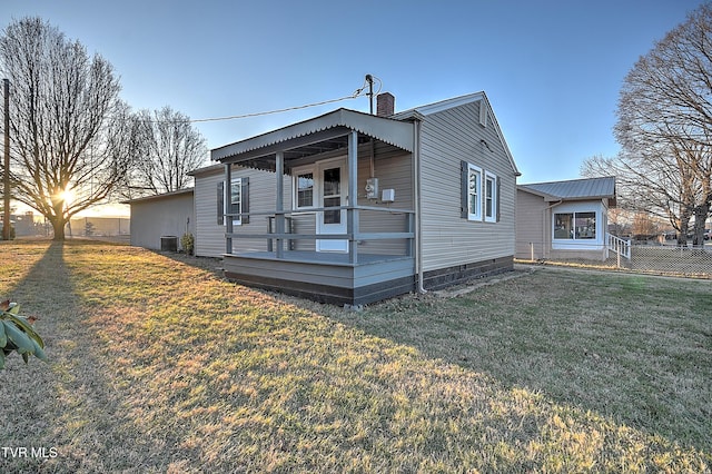 view of front of property featuring central AC and a lawn