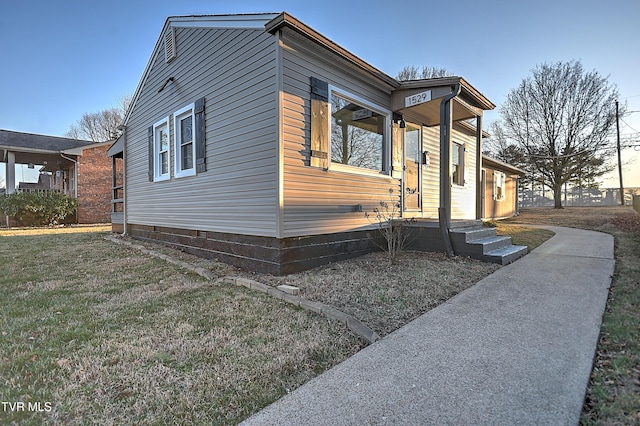 property exterior at dusk with a lawn