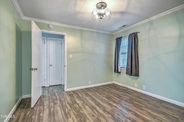 spare room featuring dark wood-type flooring and ornamental molding