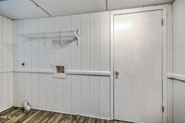 laundry room with electric dryer hookup, hookup for a washing machine, dark wood-type flooring, and wood walls