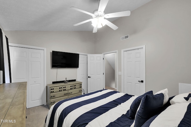 bedroom featuring multiple closets, vaulted ceiling, and ceiling fan