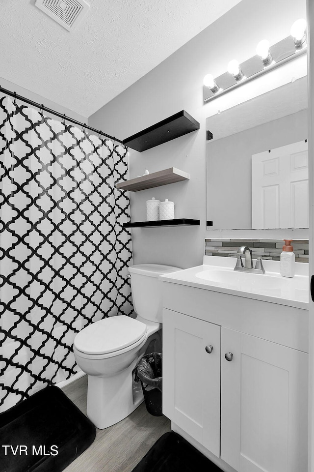 bathroom with vanity, wood-type flooring, a textured ceiling, and toilet