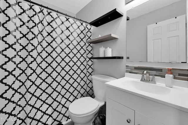 bathroom with vanity, backsplash, and toilet