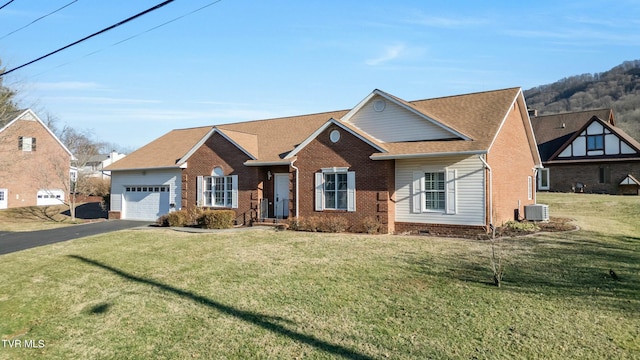 view of front of house featuring cooling unit, a garage, and a front lawn