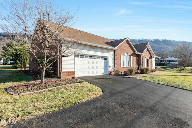 single story home featuring a garage, a mountain view, and a front yard