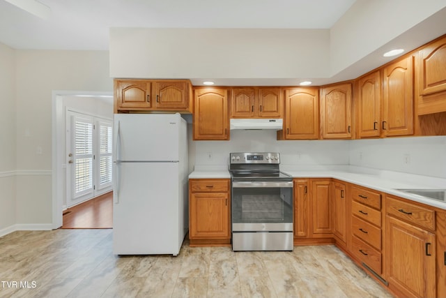 kitchen with white refrigerator, stainless steel range with electric stovetop, and sink