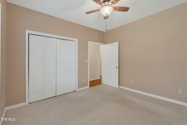 unfurnished bedroom with light colored carpet, ceiling fan, and a closet