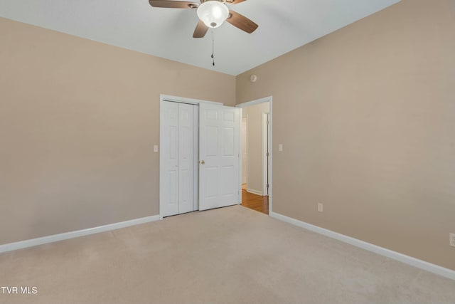 unfurnished bedroom featuring light carpet, a closet, and ceiling fan