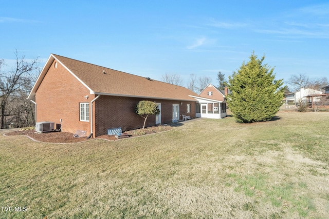 back of house with a lawn and central air condition unit