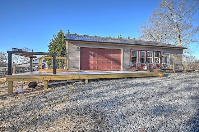 rear view of house with a wooden deck and a garage