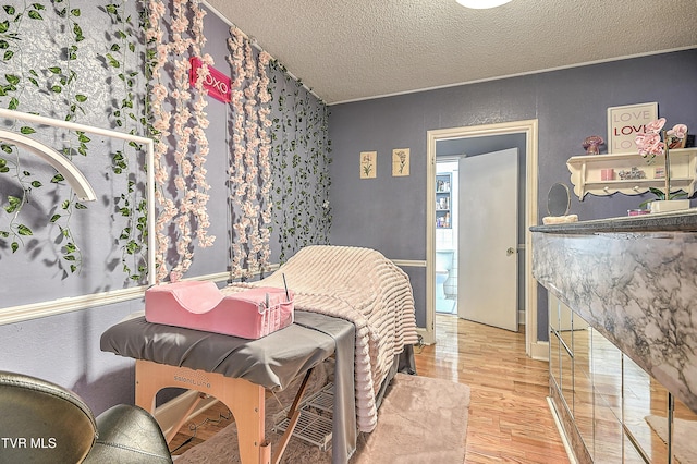 bedroom with hardwood / wood-style flooring and a textured ceiling