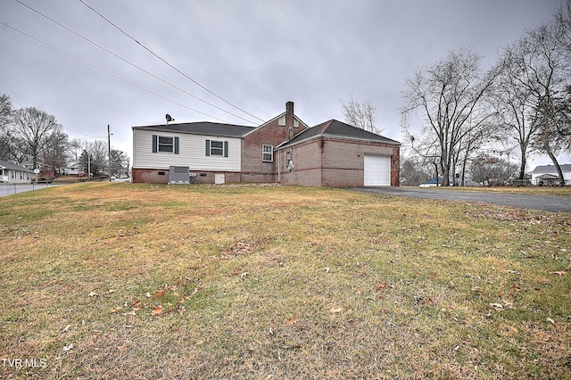 exterior space featuring central AC, a garage, and a front yard