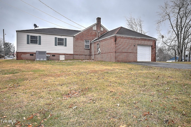 back of house featuring cooling unit, a garage, and a lawn