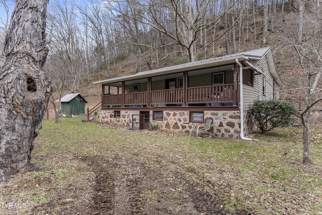 view of front of home with a storage shed and a front yard