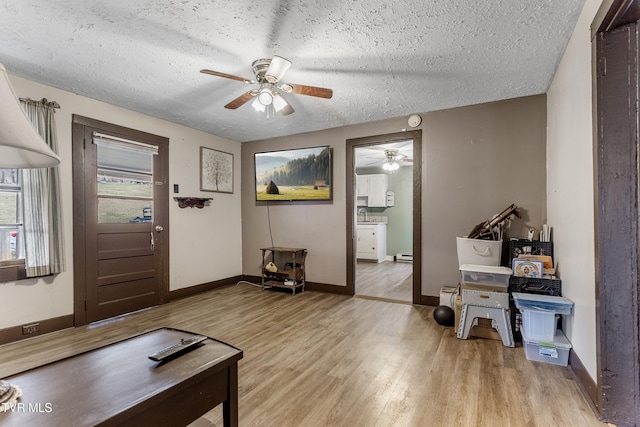 foyer entrance featuring ceiling fan, a textured ceiling, and light hardwood / wood-style floors