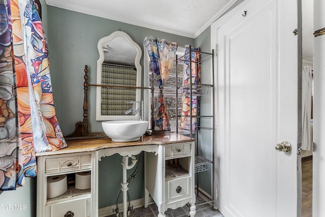 bathroom featuring crown molding and sink