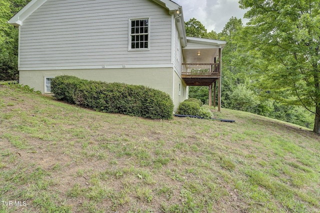 view of side of property with a lawn and a balcony