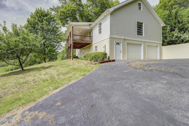 view of front of home with an attached garage, driveway, and a front lawn