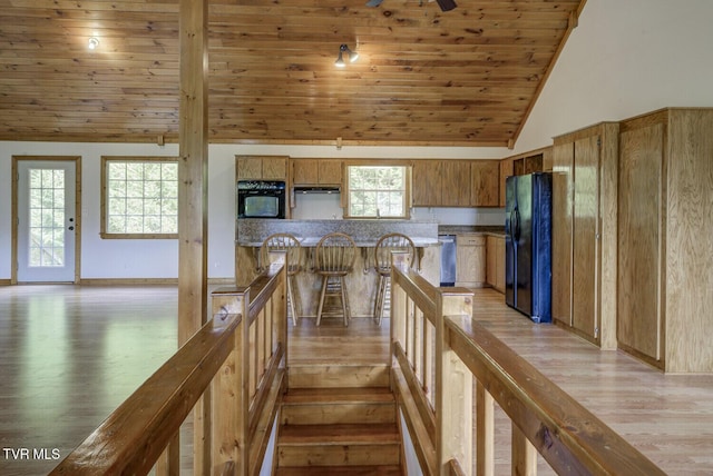 stairway featuring plenty of natural light, wood ceiling, lofted ceiling, and wood finished floors