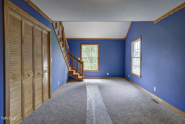 interior space featuring baseboards, vaulted ceiling, and stairway