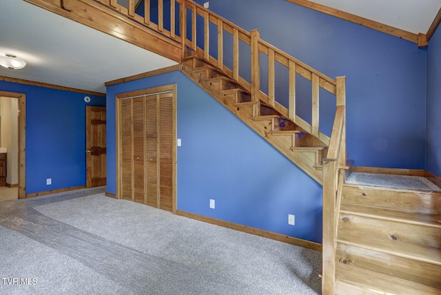 staircase featuring baseboards and carpet