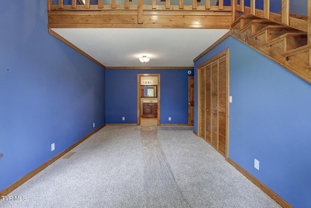 carpeted spare room with baseboards and ornamental molding