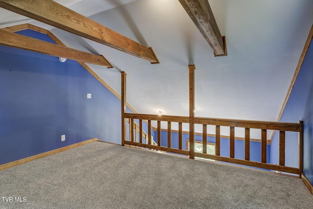 additional living space with baseboards, lofted ceiling with beams, and carpet flooring