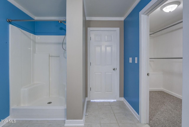 bathroom with baseboards, crown molding, and walk in shower
