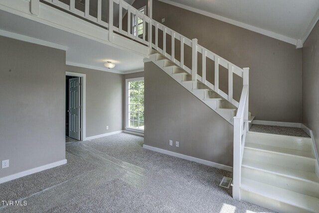 stairs with crown molding, carpet floors, baseboards, and visible vents