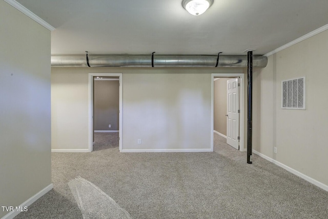 finished basement with carpet floors, ornamental molding, baseboards, and visible vents