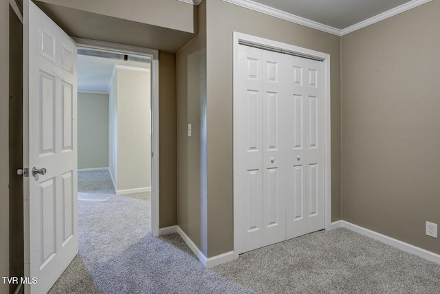 hall with carpet floors, crown molding, and baseboards