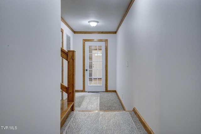 entryway with carpet floors, baseboards, and stairway
