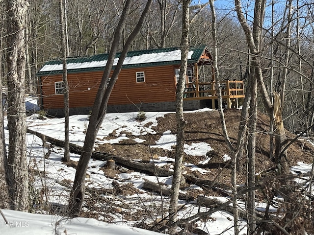 view of snowy exterior with a wooden deck