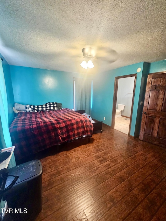 bedroom with ceiling fan, hardwood / wood-style floors, and a textured ceiling