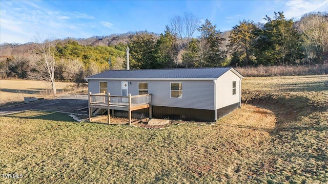 view of front of property featuring a wooden deck and a front yard