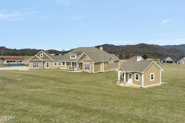 view of front of property with a mountain view and a front yard