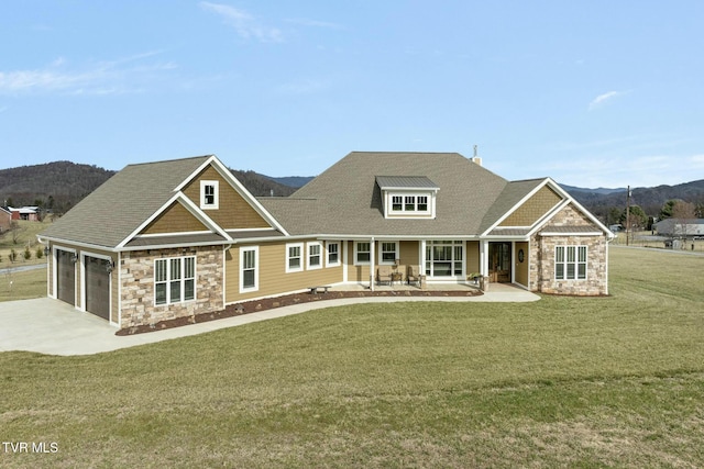 craftsman house featuring a mountain view, a garage, a front lawn, and covered porch