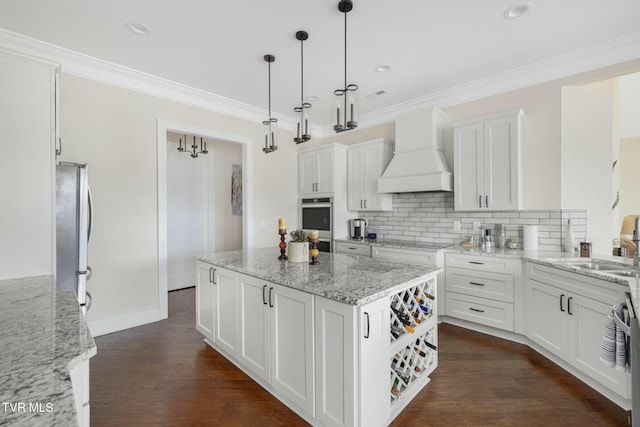 132 Hamilton Rd, Elizabethton, TN 37643 - kitchen with a kitchen island, appliances with stainless steel finishes, white cabinets, hanging light fixtures, and custom range hood