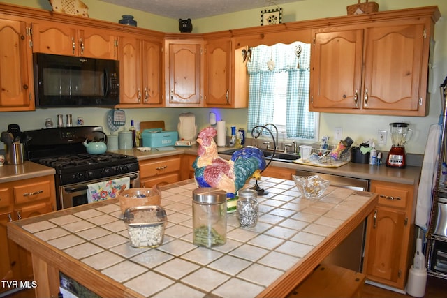 kitchen with sink, gas range, and tile countertops