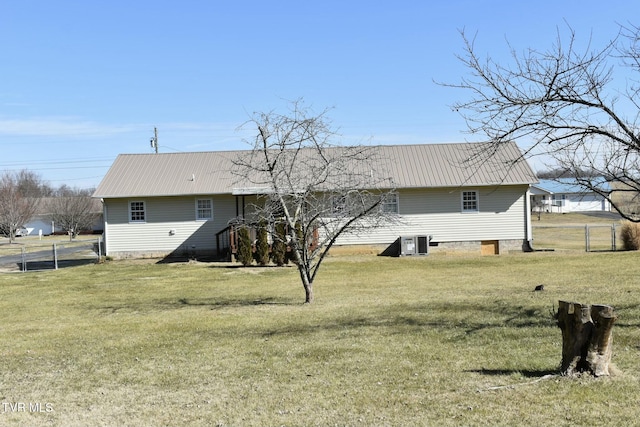 back of property featuring central AC and a lawn